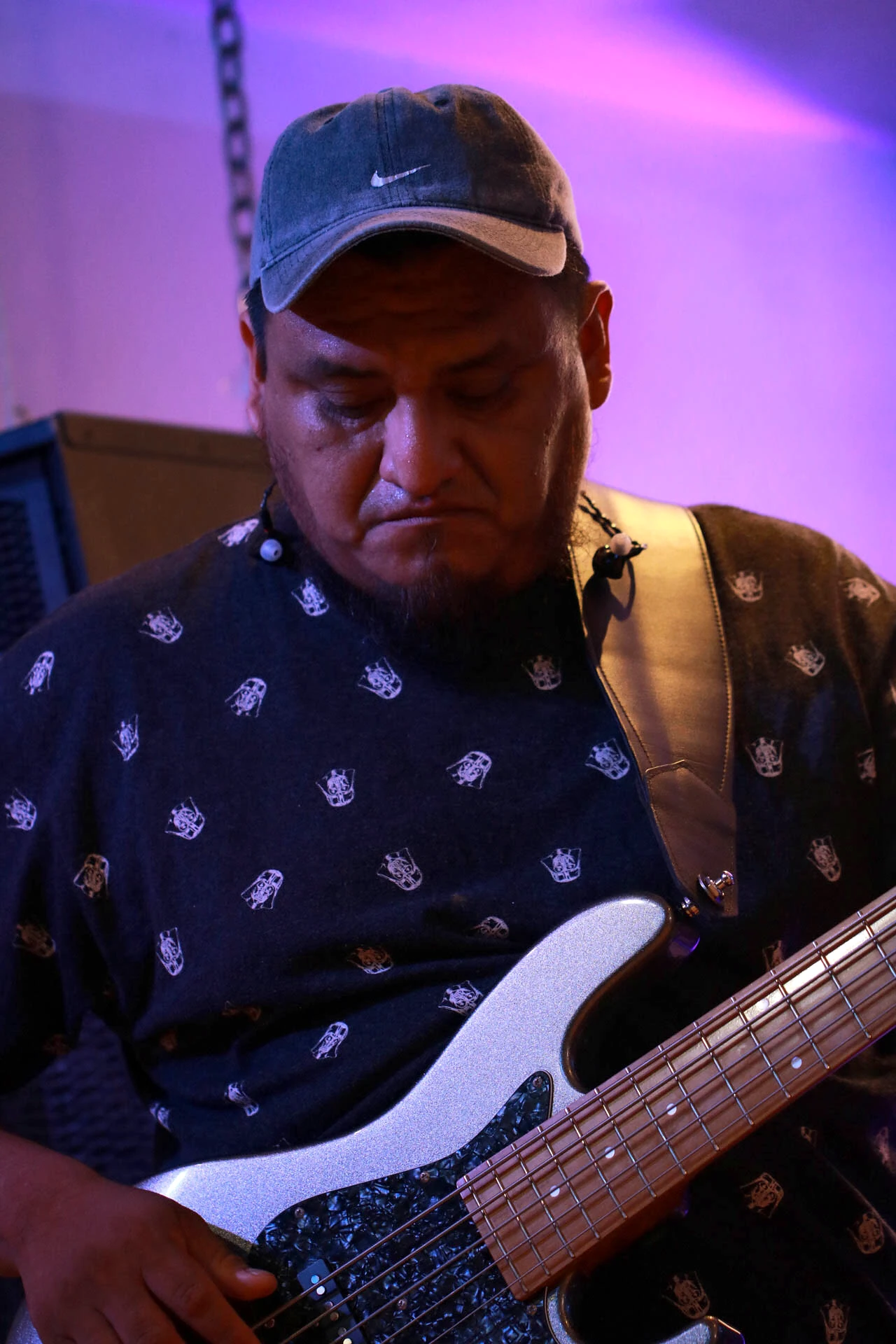 Bajista tocando un bajo eléctrico blanco sobre el escenario de Comunidad Más Alto